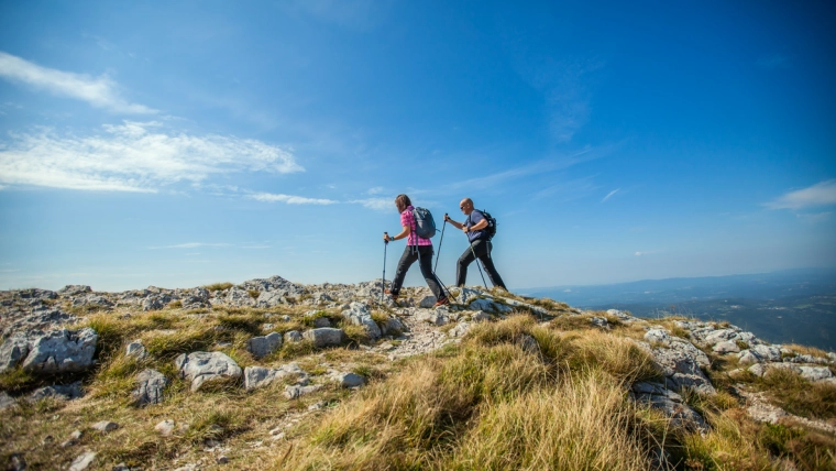un couple de randonneurs sur un sommet avec un beau ciel